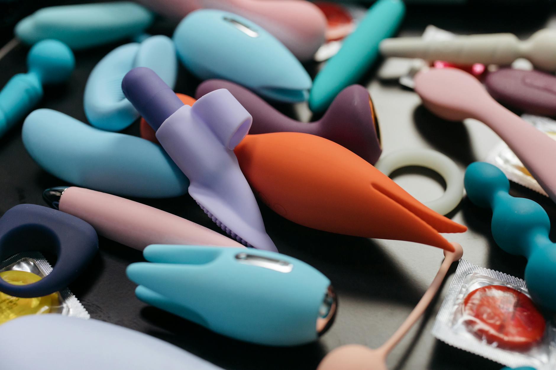 An array of vibrant adult toys including vibrators and rings in a close-up view